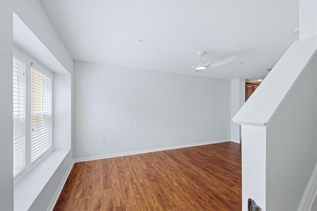 9038 White Sage Loop Lakewood Ranch, FL 34202 - Photo 17 of 52 a view of empty room with wooden floor and fan