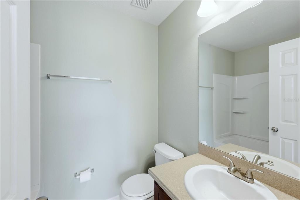 9038 White Sage Loop Lakewood Ranch, FL 34202 - Photo 28 of 52 a bathroom with a toilet sink vanity and shower