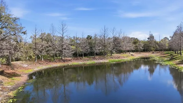 a backyard of a house with lots of green space and lake view
