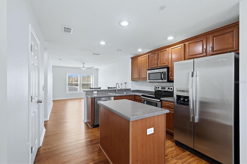 9038 White Sage Loop Lakewood Ranch, FL 34202 - Photo 10 of 52 a kitchen with stainless steel appliances granite countertop a refrigerator a stove a sink a oven and a refrigerator