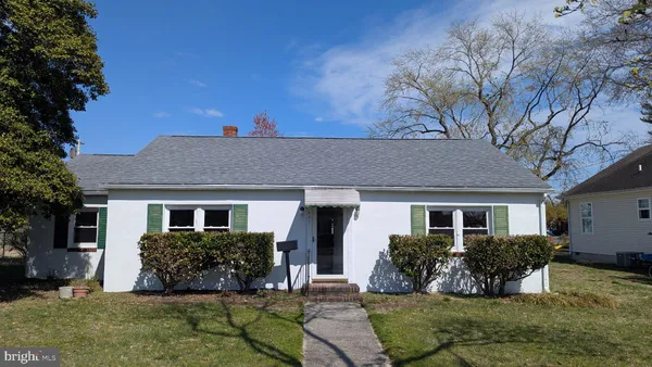 a view of house with yard and outdoor seating