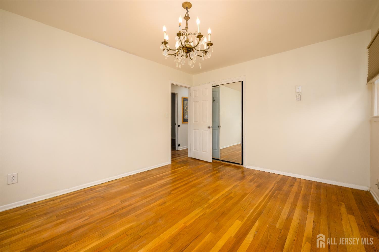 178 Grant Avenue Colonia, NJ 07067 - Photo 21 of 39 a view of a livingroom with wooden floor and a chandelier