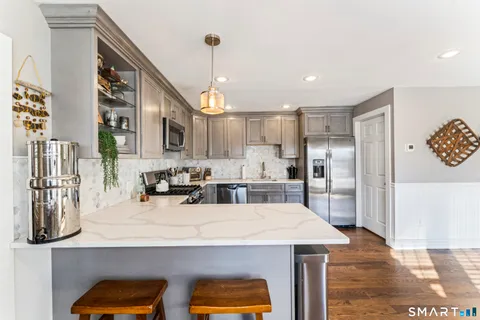 a kitchen with stainless steel appliances granite countertop a sink a stove and a refrigerator