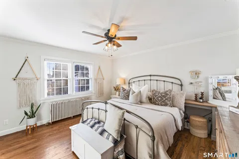 a bedroom with a bed wooden floor and window