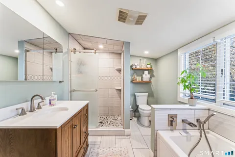 a bathroom with a sink a toilet and shower