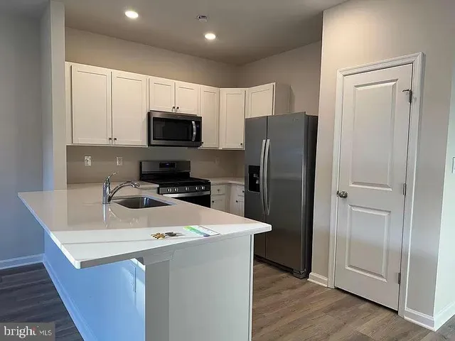 a kitchen with a refrigerator a microwave and sink
