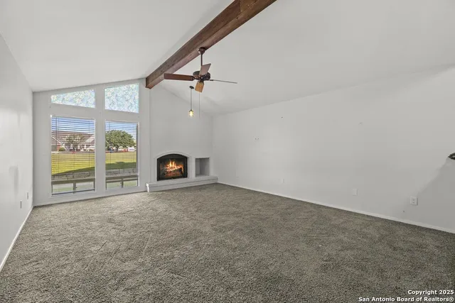 a view of an empty room with a fireplace and a window