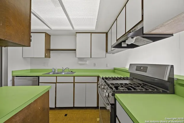 a kitchen with a sink a stove and cabinets