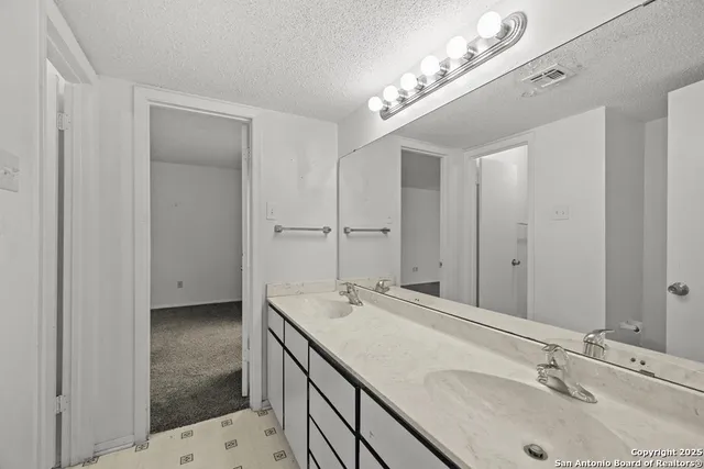 a bathroom with a granite countertop sink a toilet and shower