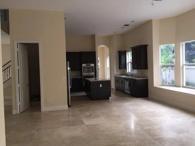 a living room with furniture a flat screen tv and large windows