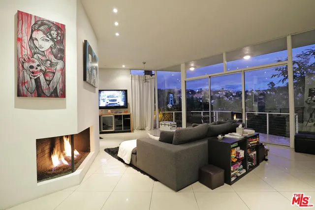 a living room with furniture a floor to ceiling window and potted plants