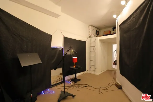 a living room with a table chairs and a refrigerator