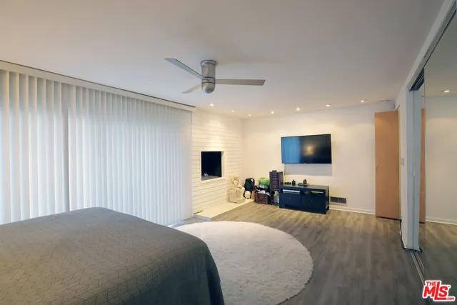 a bedroom with a bed a couch and a flat screen tv