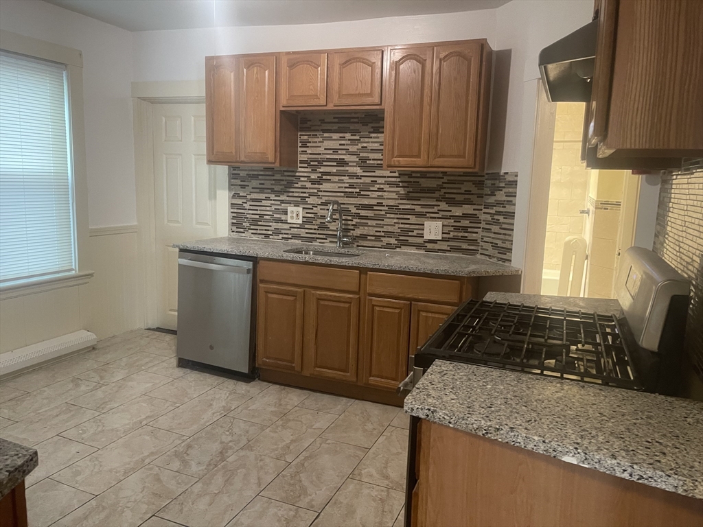 6 Bailey Street, Unit 1 Boston, MA 02124 - Photo 3 of 12 a kitchen with granite countertop a sink stove and cabinets