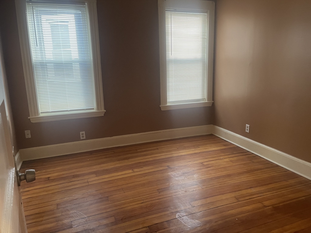 6 Bailey Street, Unit 1 Boston, MA 02124 - Photo 7 of 12 an empty room with wooden floor and windows