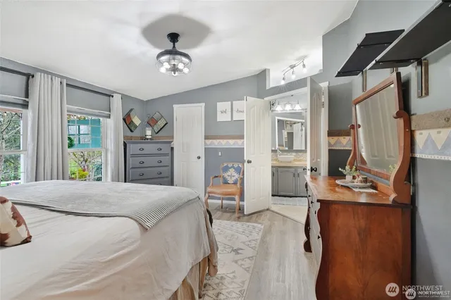 a bedroom with a bed dresser and a large window