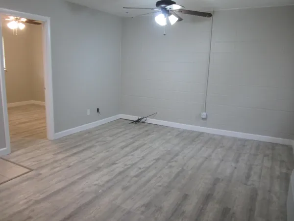 a view of an empty room with wooden floor
