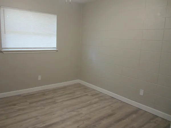 a view of a small space with wooden floor and a window