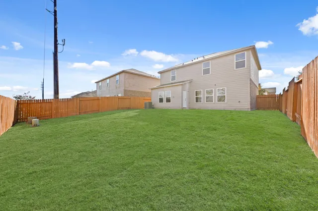 a backyard of a house with plants and wooden fence