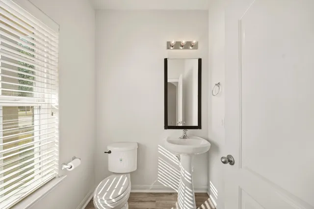 a bathroom with a toilet sink and mirror