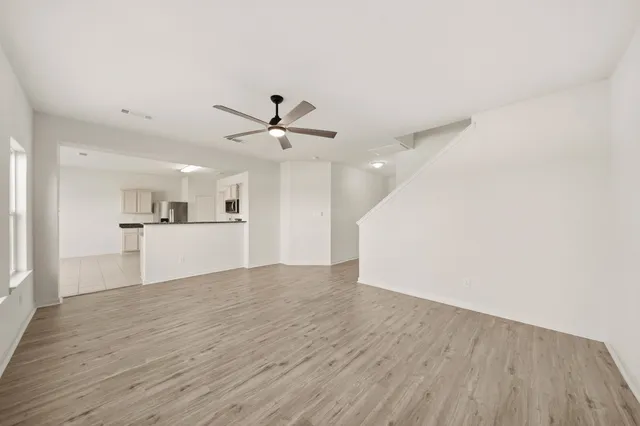 a view of a kitchen with wooden floor and a ceiling fan