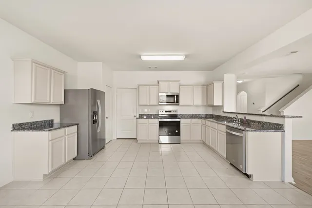a kitchen with stainless steel appliances and white cabinets
