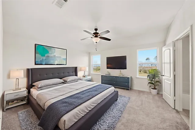 a spacious bedroom with a bed and a flat screen tv