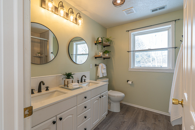 1045 Fox Farm Road Logan, UT 84321 - Photo 35 of 65 Full bath with double vanity, dark wood-style floors, healthy amount of natural light, a textured ceiling, and a shower with shower curtain