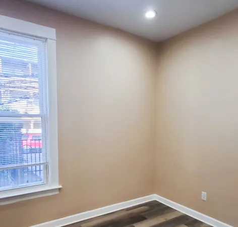 a view of a small space with wooden floor and a window