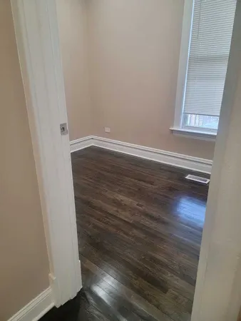 a view of a small space with wooden floor and a window