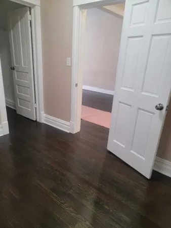 an empty room with wooden floor and closet