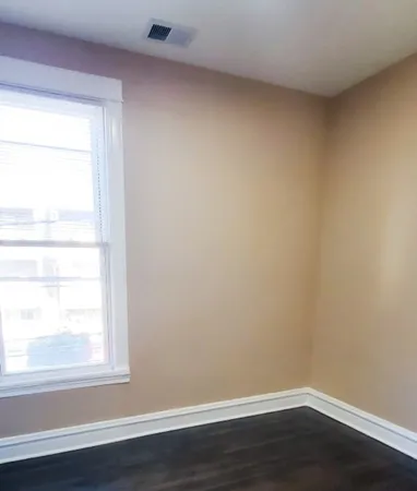 a view of a small space with wooden floor and a window