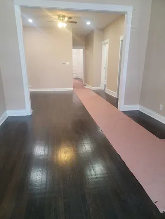 a view of an empty room with wooden floor