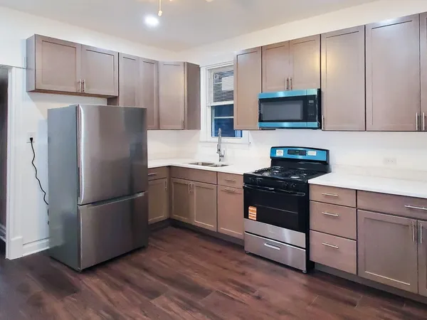 a kitchen with stainless steel appliances a refrigerator stove and microwave