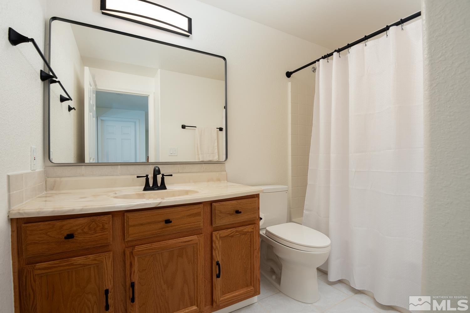 4651 Reds Grade Carson City, NV 89703 - Photo 23 of 39 a bathroom with a granite countertop sink a toilet and a mirror