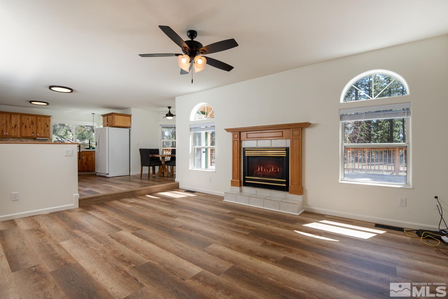 4651 Reds Grade Carson City, NV 89703 - Photo 4 of 39 a view of a livingroom with a fireplace a ceiling fan and windows