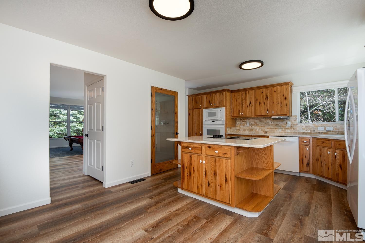 4651 Reds Grade Carson City, NV 89703 - Photo 7 of 39 a kitchen with stainless steel appliances granite countertop a stove a sink and a wooden floors