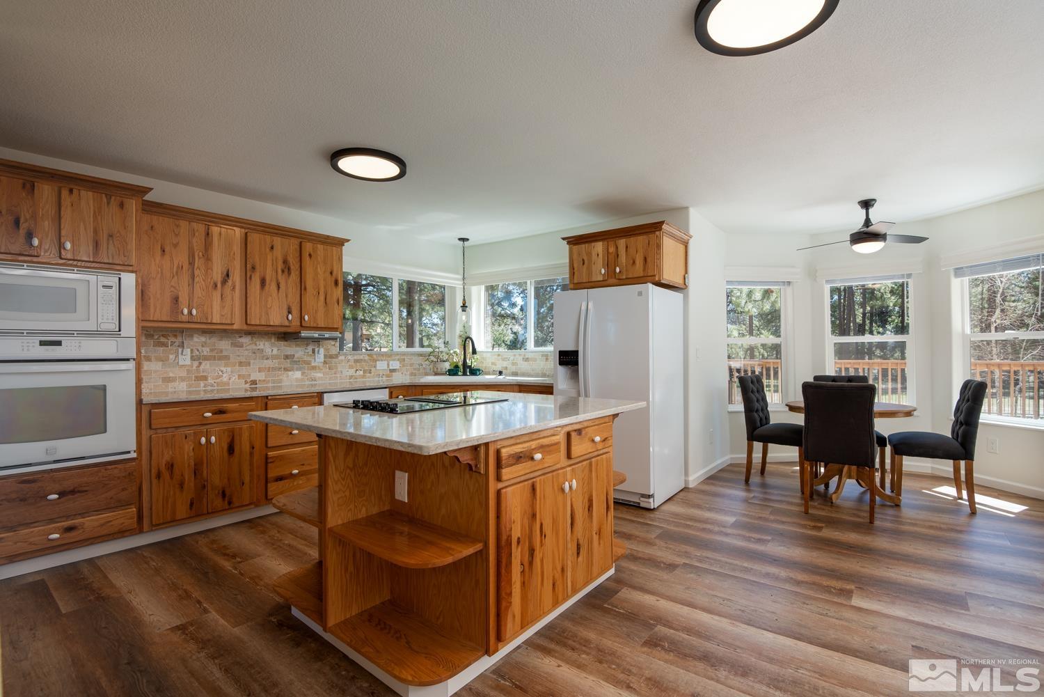 4651 Reds Grade Carson City, NV 89703 - Photo 8 of 39 a kitchen with granite countertop a stove a sink dishwasher and a refrigerator with wooden floor