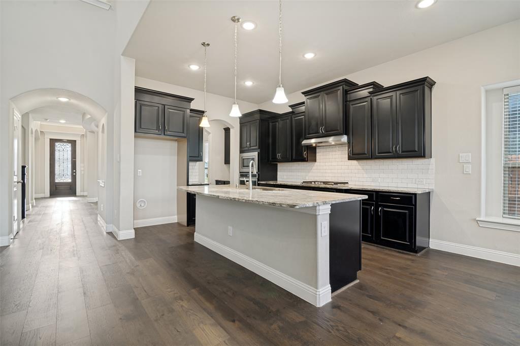 2802 Merlot Circle Rowlett, TX 75088 - Photo 11 of 40 a large kitchen with stainless steel appliances kitchen island granite countertop a stove and a wooden floors