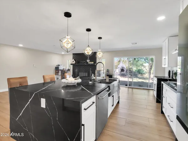 a kitchen with kitchen island granite countertop a sink a counter top space appliances and cabinets