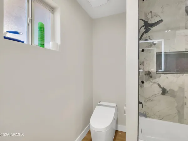 a white toilet sitting next to a shower