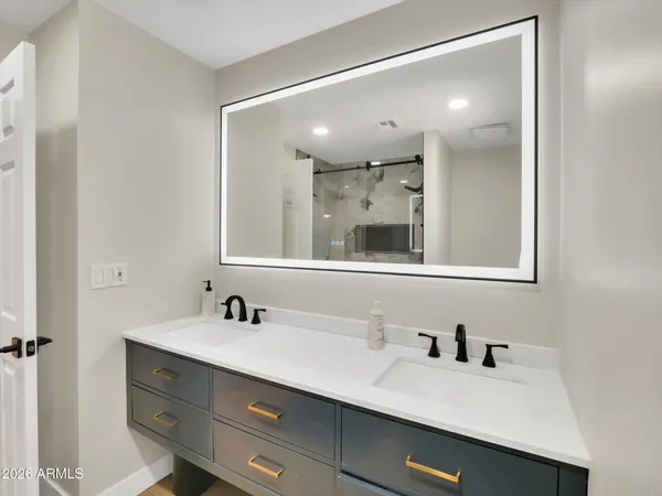 a bathroom with a sink double vanity and a mirror