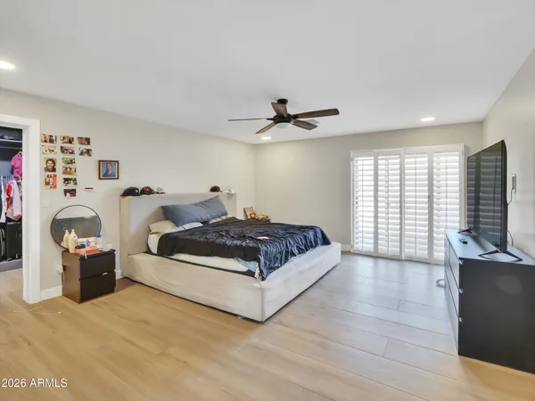 a spacious bedroom with a bed and a flat screen tv