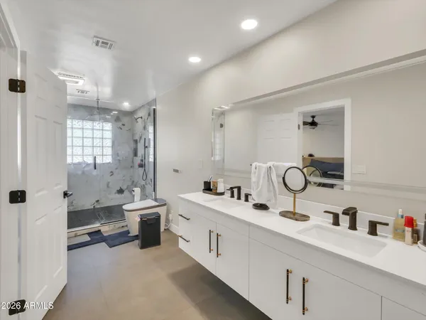 a bathroom with double vanity sinks double vanity tub shower and a mirror