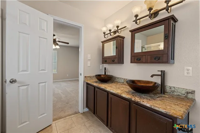 a bathroom with a granite countertop sink a mirror and vanity