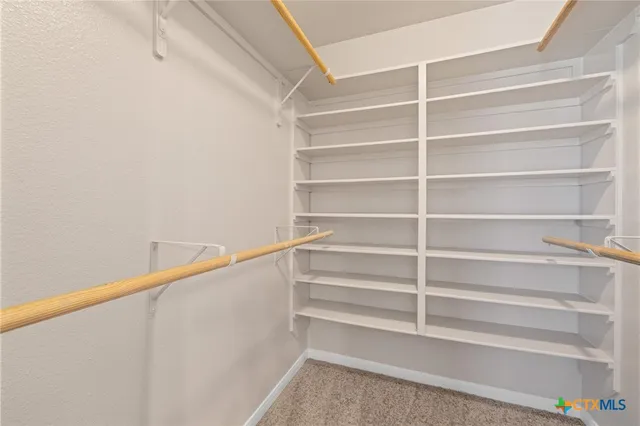 a view of walk in closet with empty racks