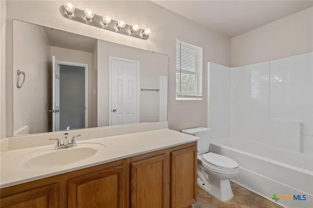 a bathroom with a sink a toilet a mirror and shower