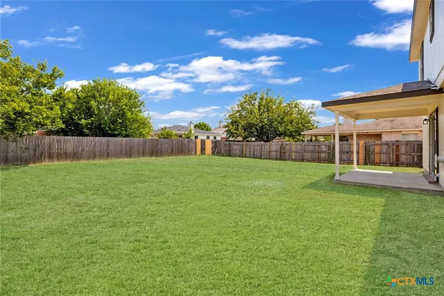 a view of yard with swimming pool and green space