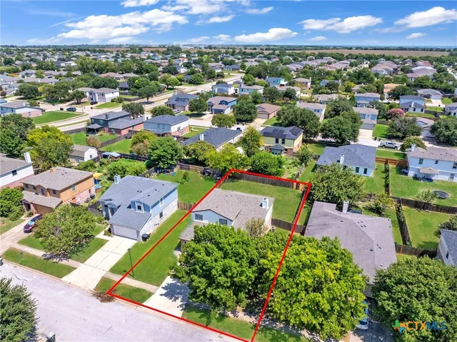 an aerial view of a houses with a yard