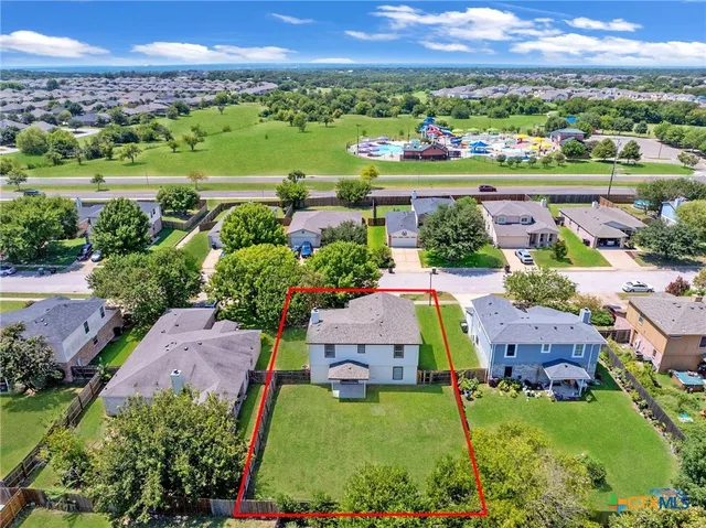 an aerial view of a city with lots of residential buildings and mountain view in back